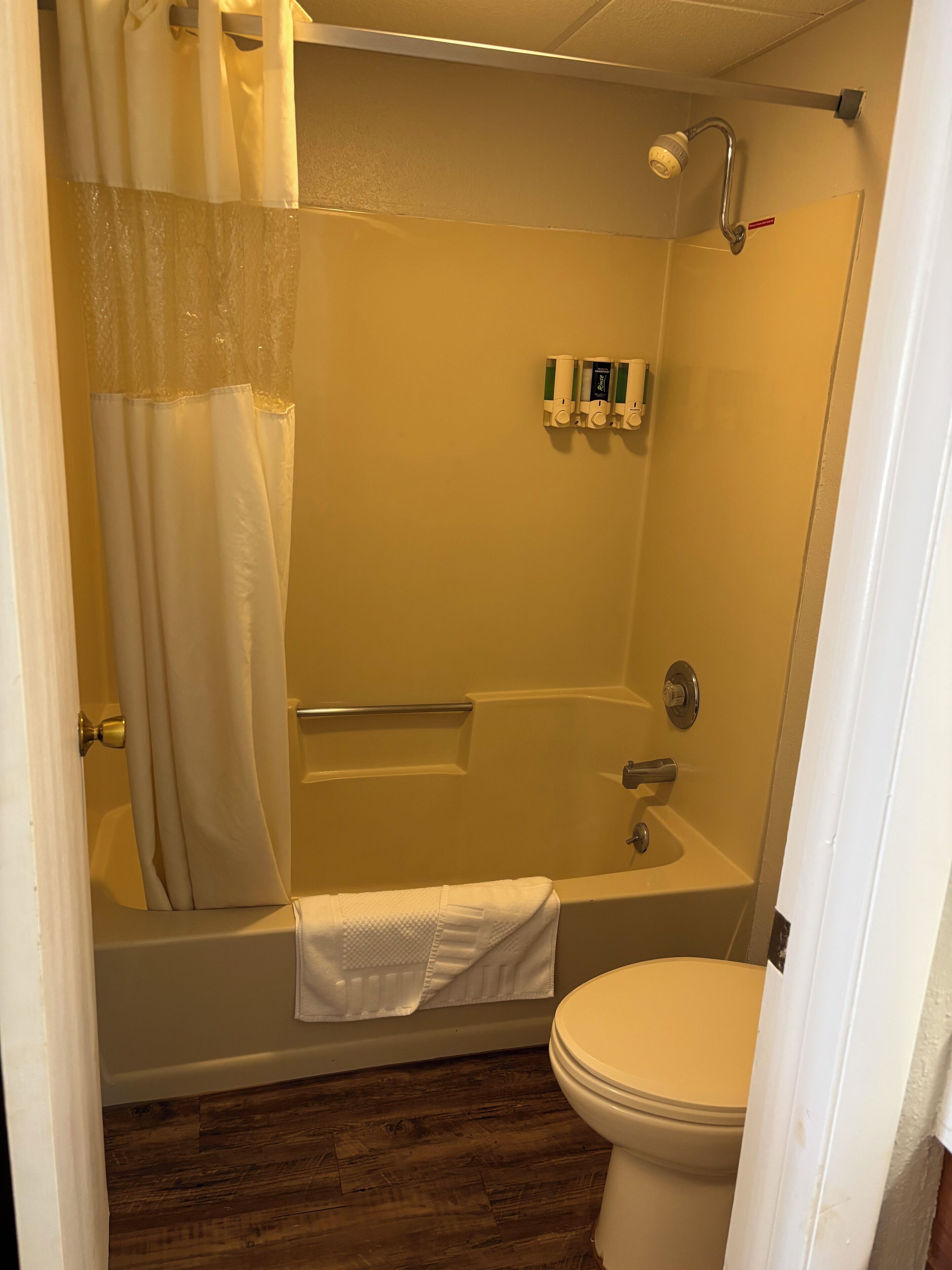 A bathroom with a bathtub, toilet, and shower.