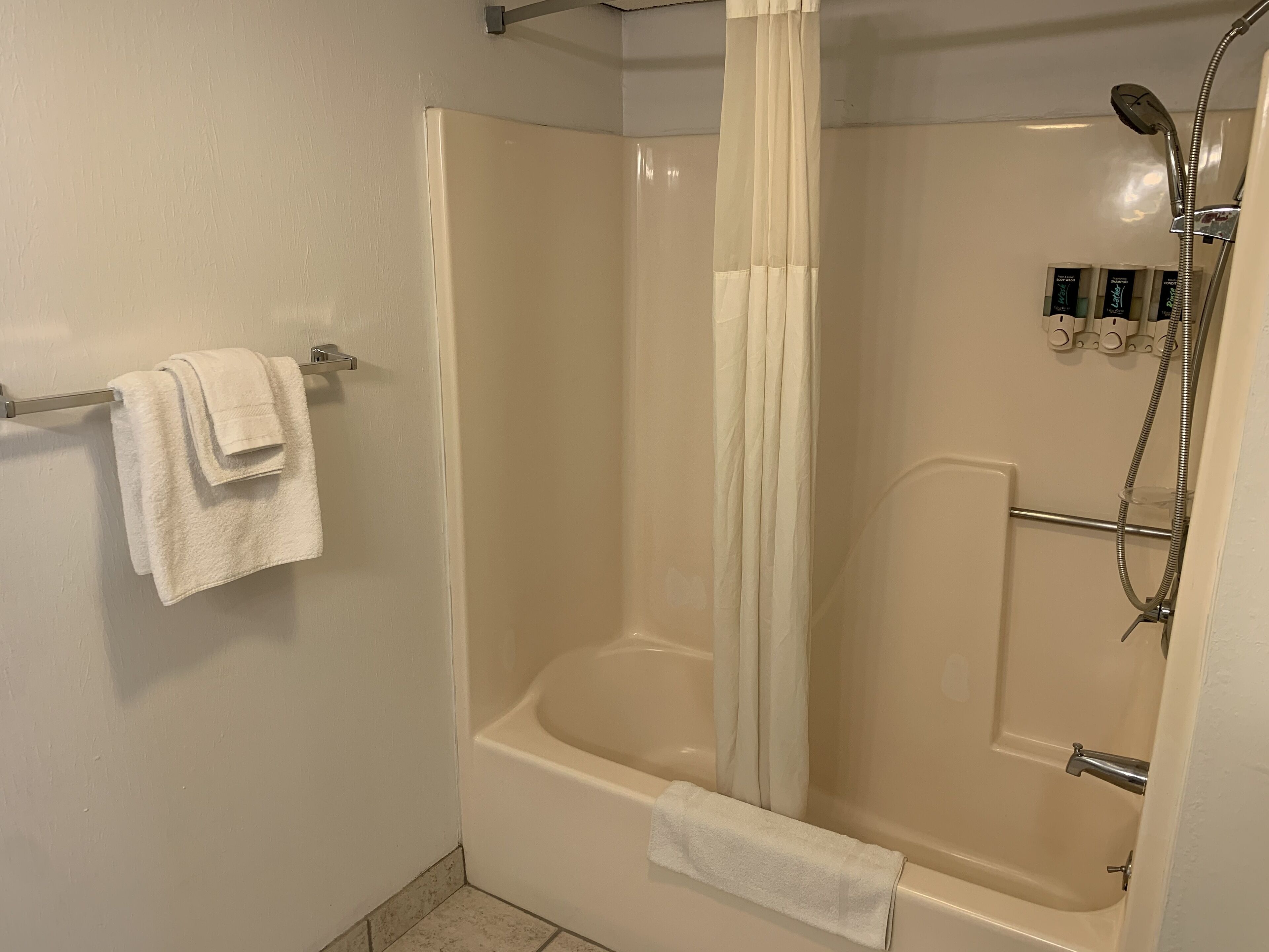 Un baño moderno con bañera, ducha y perchero para toallas.