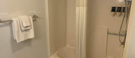 Un baño moderno con bañera, ducha y perchero para toallas.