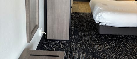 A hotel room with a bed, a desk, a TV, and a bathroom.