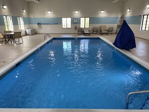 An indoor swimming pool with clear blue water, tiled walls, and a few lounge chairs. - Staybridge Suites, Lincolnshire by IHG (Lincolnshire)