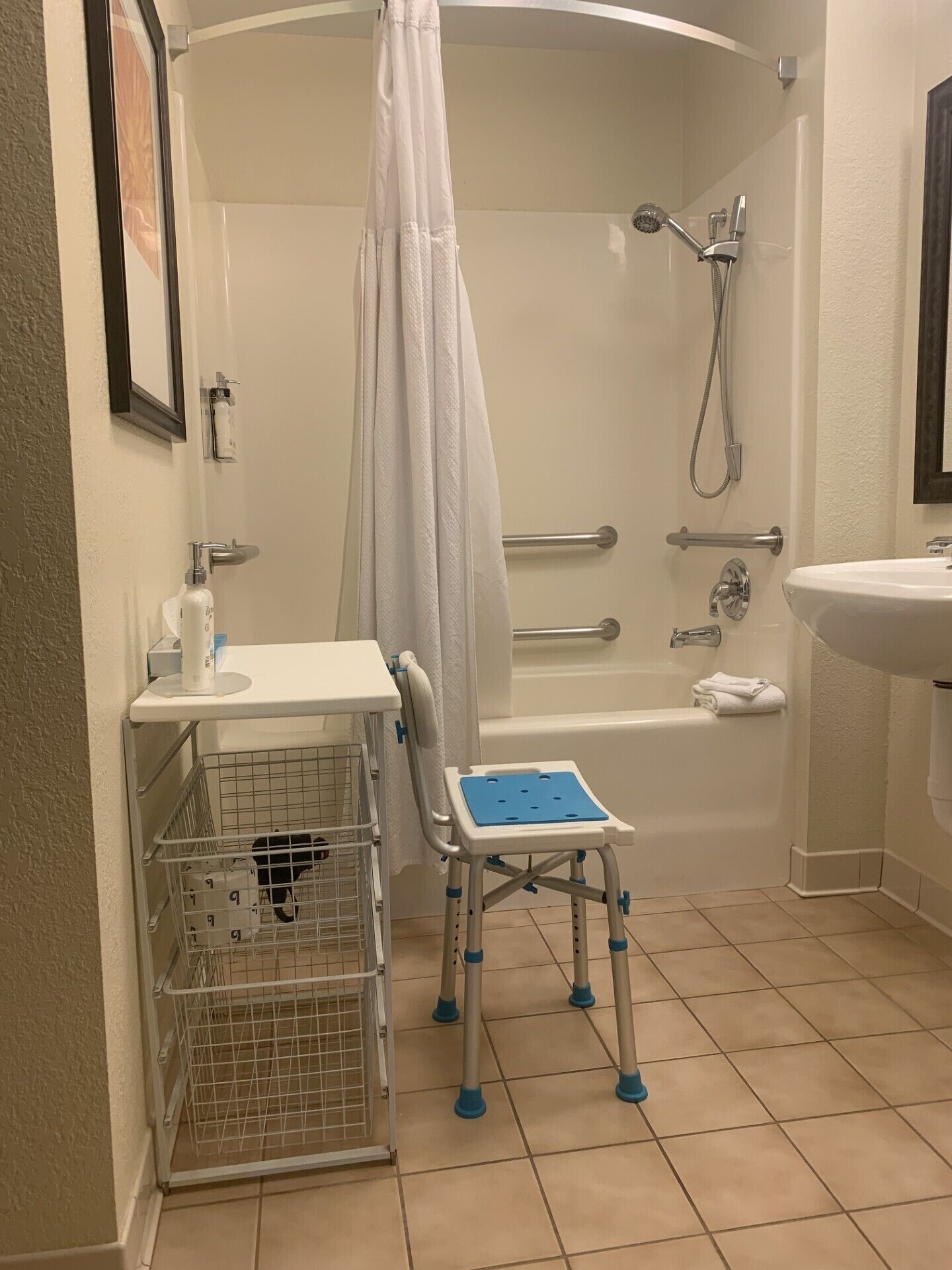 A bathroom with a shower, a sink, a toilet, and a baby changing station.