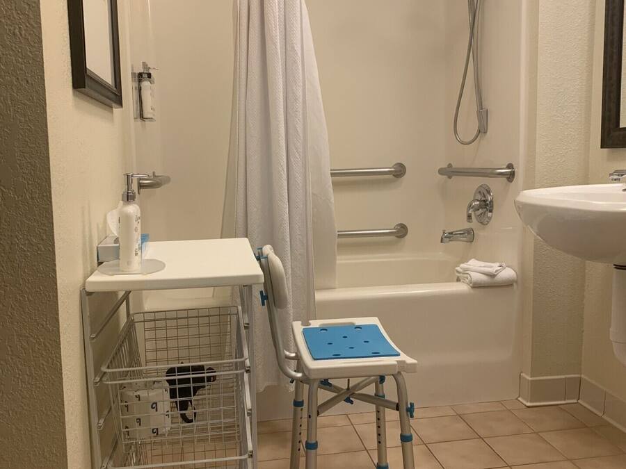 A bathroom with a shower, a sink, a toilet, and a baby changing station.