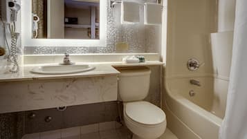 A modern bathroom with a bathtub, toilet, and vanity.