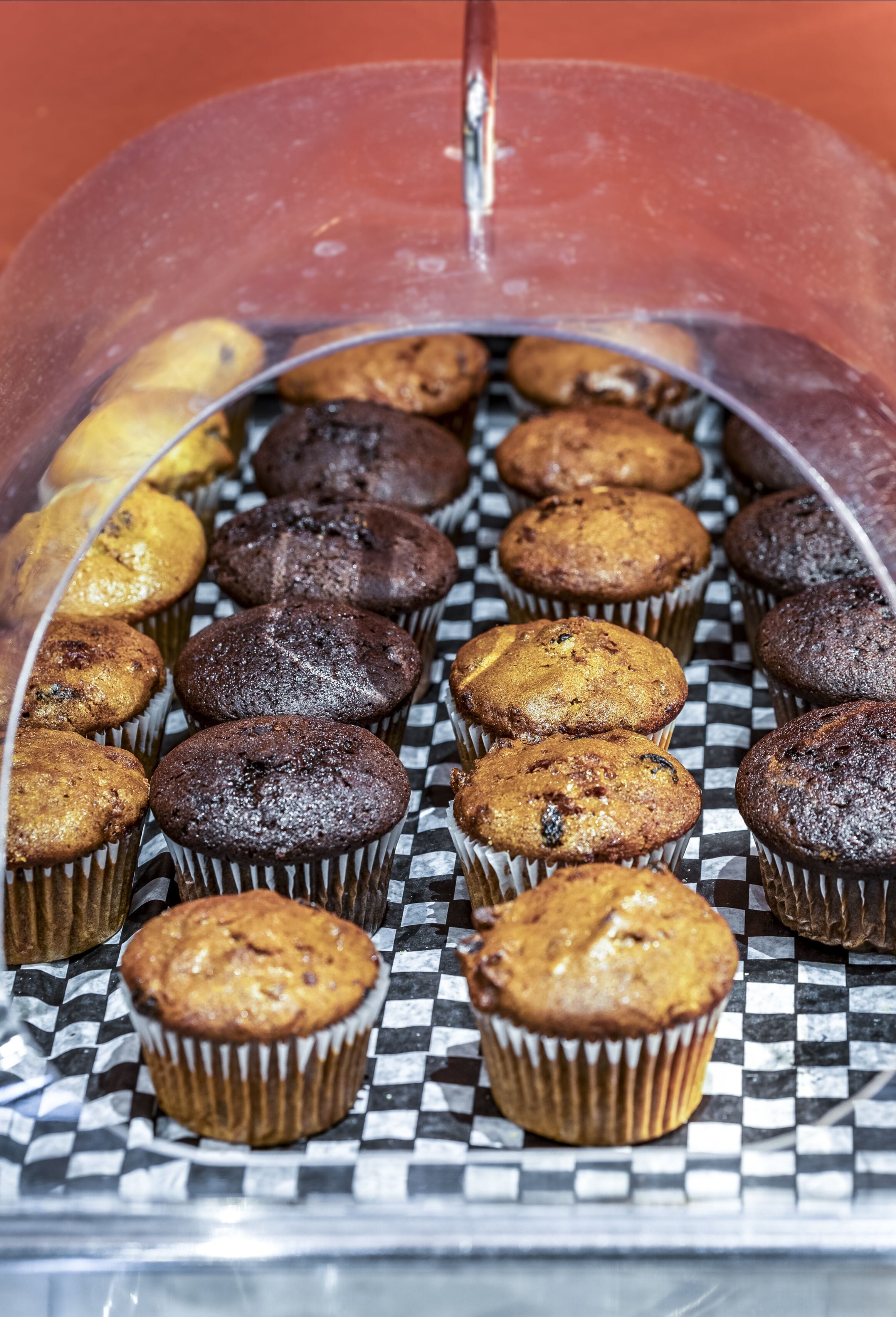 Une présentation de muffins dans des moules en papier, disposés sur un plateau à carreaux.