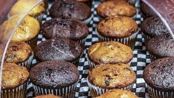 Une présentation de muffins dans des moules en papier, disposés sur un plateau à carreaux.