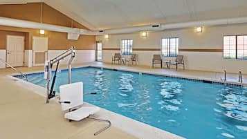 Una piscina techada, sillones reclinables de piscina