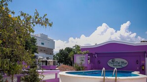 Un área de piscina en la azotea con sillones de descanso y una fuente decorativa.