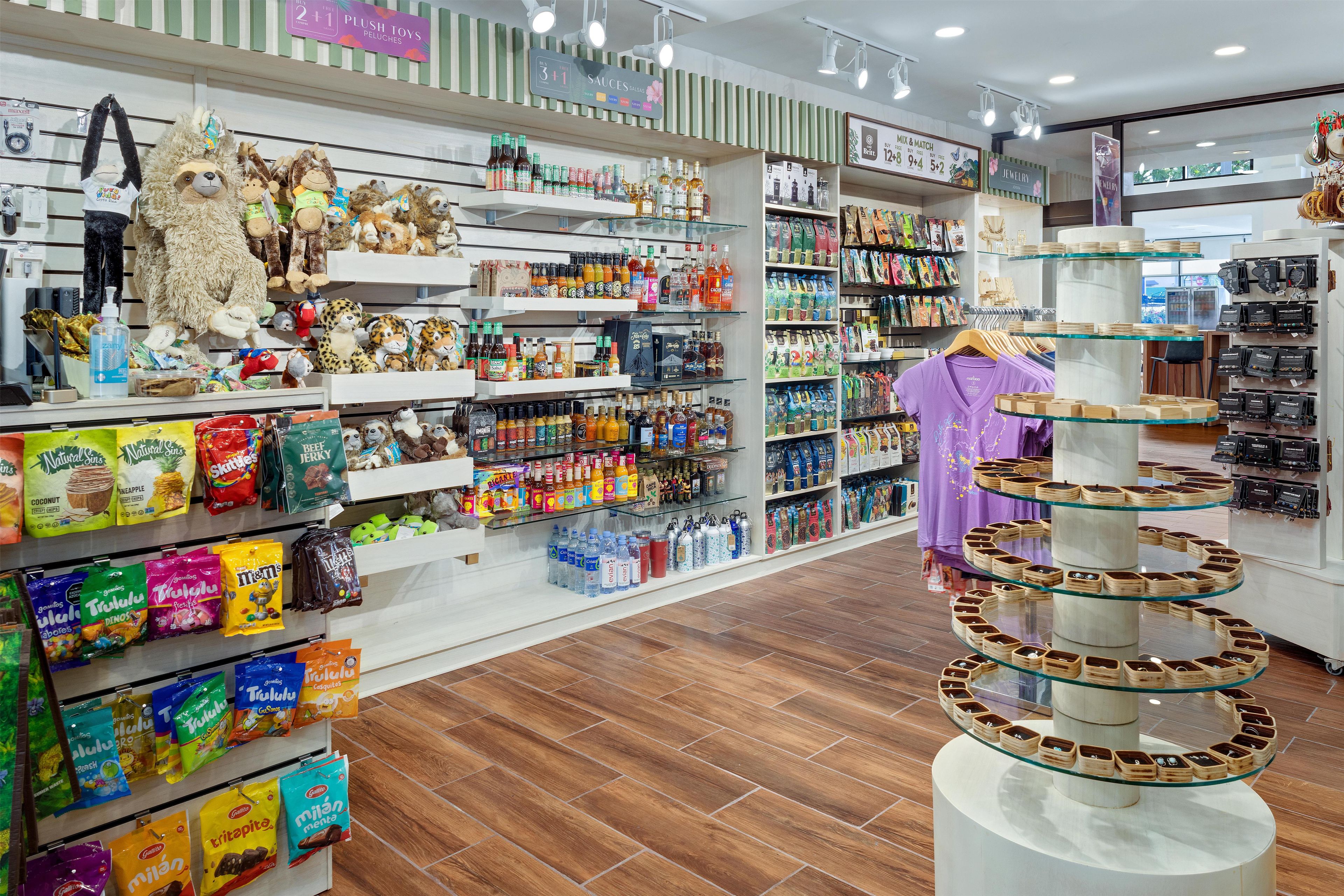 Una tienda con estantes llenos de aperitivos, bebidas y peluches.