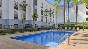 Una piscina al aire libre, sombrillas, tumbonas