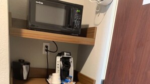 Une petite cuisine équipée d’un four à micro-ondes, d’une machine à café et d’un réfrigérateur.