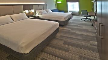 A hotel room with two beds, a desk, and a chair.
