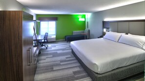 Une chambre d’hôtel avec un grand lit, un bureau, une chaise et un mur vert.