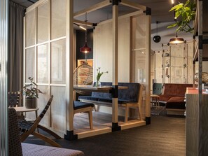 A modern interior with a seating area, a hanging light fixture, and a plant. - Oru Hub Hotel Tallinn - Handwritten Collection (Tallinn)