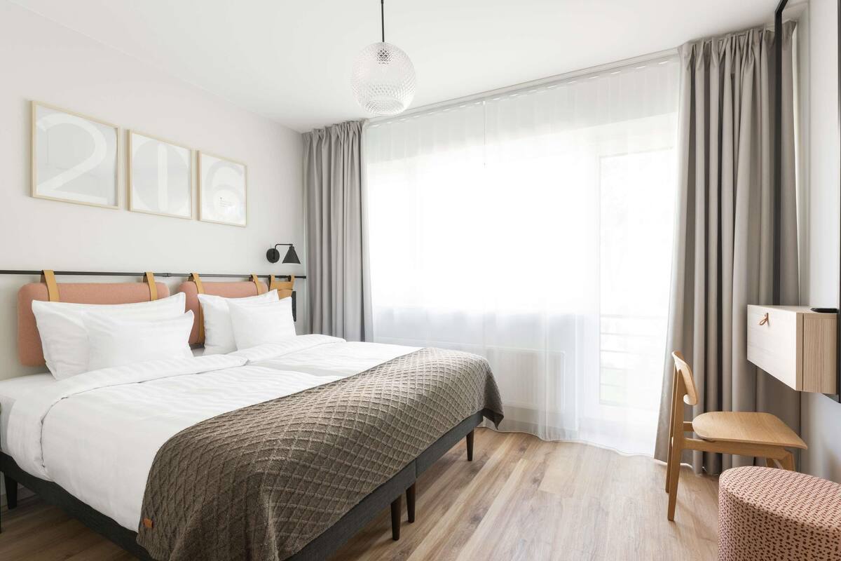 Une chambre à coucher moderne avec un grand lit, un bureau et une chaise.