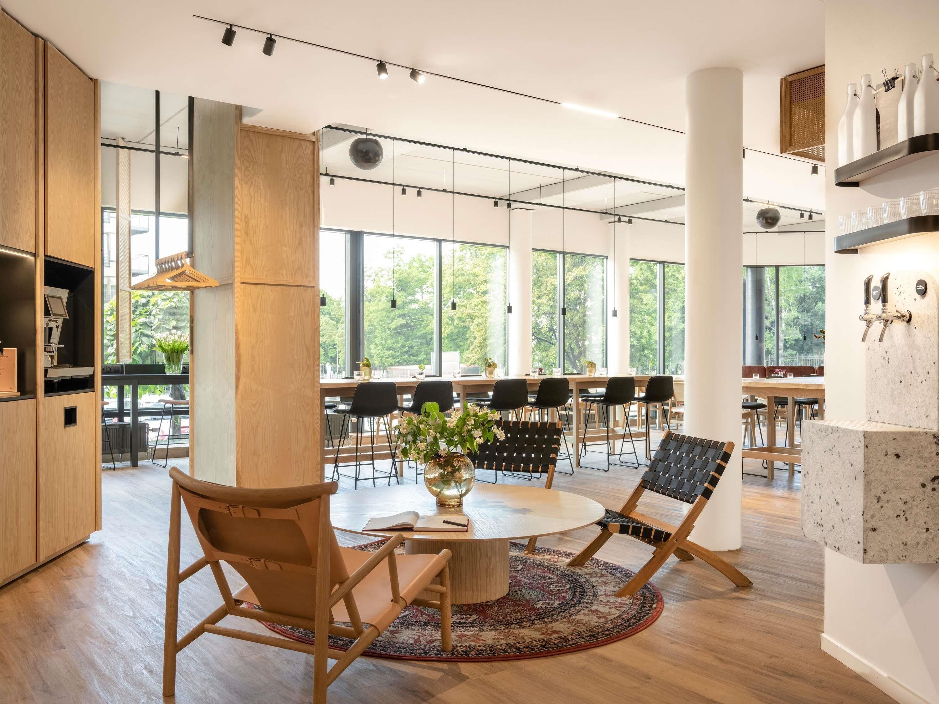A modern interior with a round table, chairs, and a coffee machine.