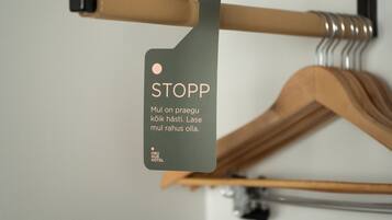 A wooden hanger with a metal clip and a tag that reads "STOPP" and "Mul on praegu kock hasti. Lase mul rahus olla."