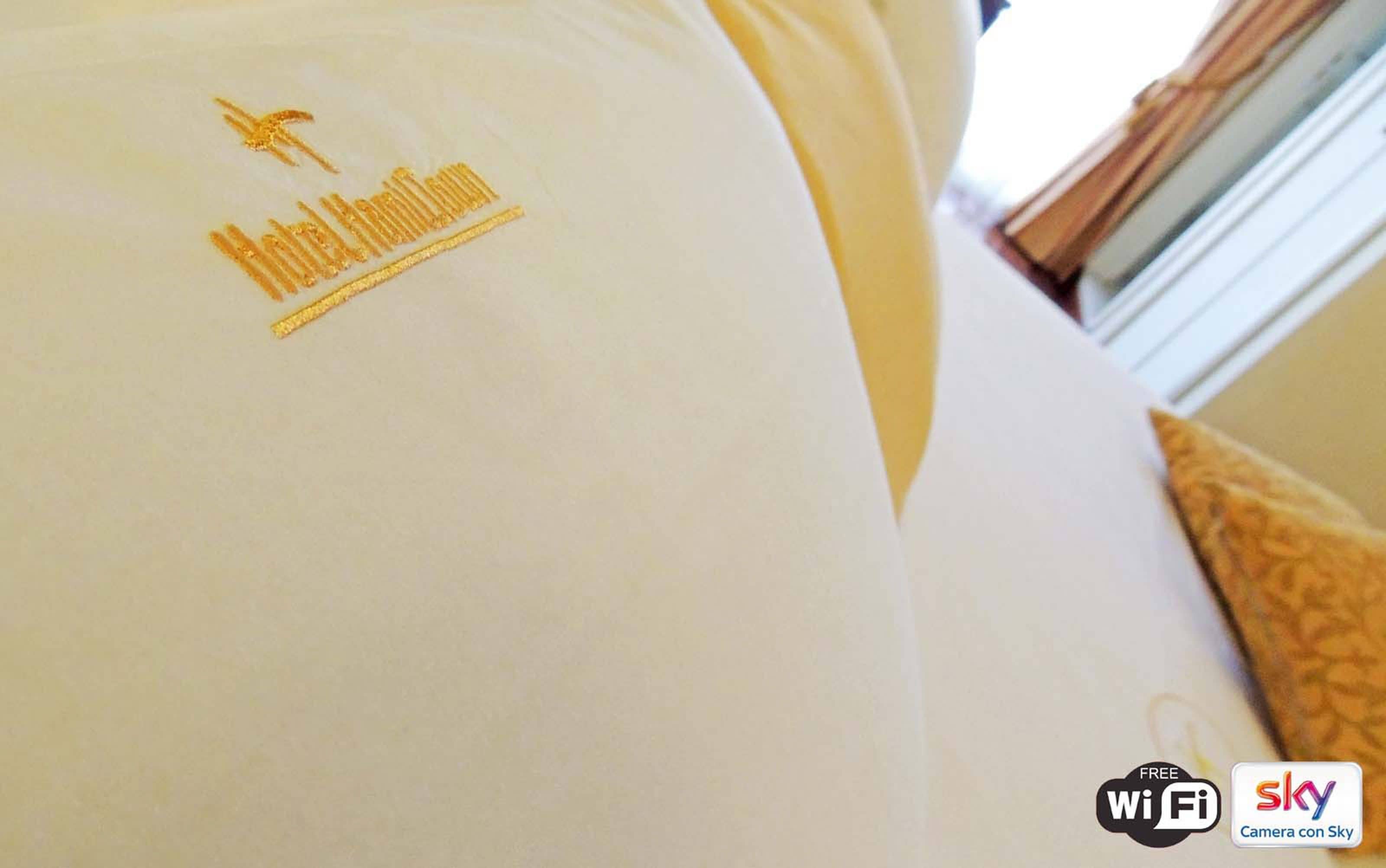 A white pillow with a logo and text indicating a hotel brand.