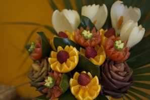 A bouquet of flowers with strawberries and orange slices arranged in a decorative pattern. - Giglio (Montecatini Terme)
