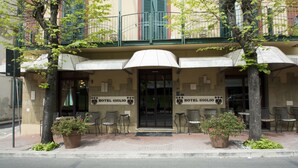 A hotel entrance with outdoor seating and potted plants.