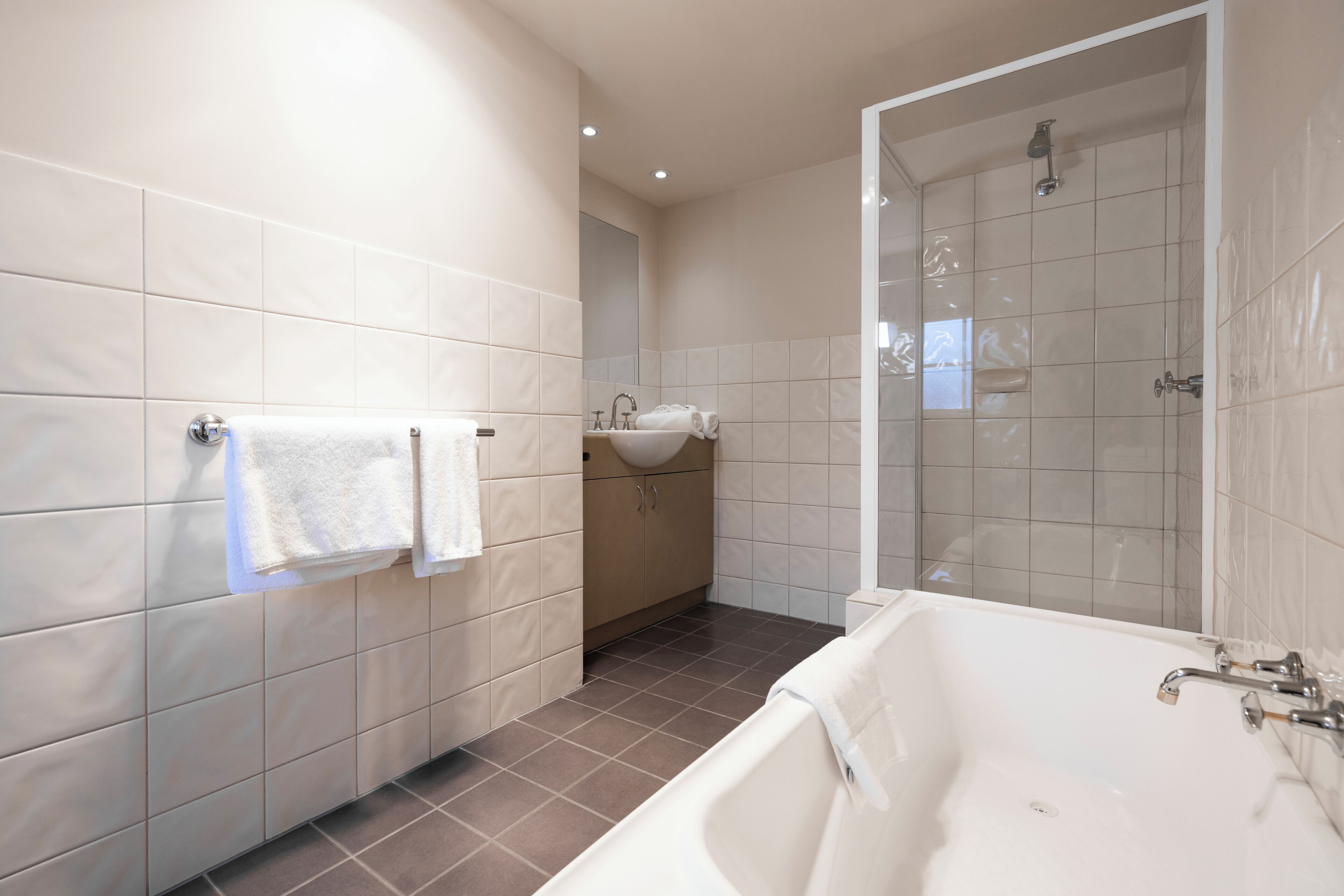 A modern bathroom with a bathtub, a shower, and a sink.