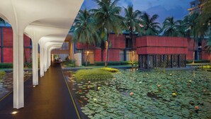 A modern hotel corridor with a water feature and palm trees.