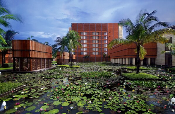 A hotel courtyard with a water garden, palm trees, and a modern building with a brick facade. - ITC Sonar, a Luxury Collection Hotel, Kolkata (Kolkata)