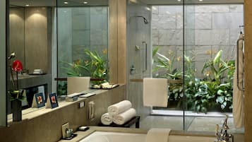 A modern bathroom with a large bathtub, a glass-enclosed shower, and a vanity with a mirror.
