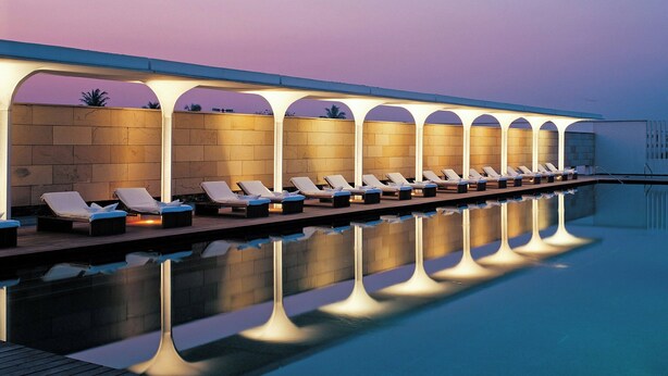 A poolside area with lounge chairs and a reflection pool.