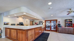 A reception area with a wooden counter, a clock, and a reception desk. - SureStay Plus Hotel by Best Western Redding (Redding)