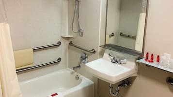 A bathroom with a bathtub, a sink, a mirror, and a shower.