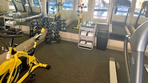A gym with exercise equipment including treadmills, dumbbells, and an exercise bike. - SureStay Plus Hotel by Best Western Redding (Redding)