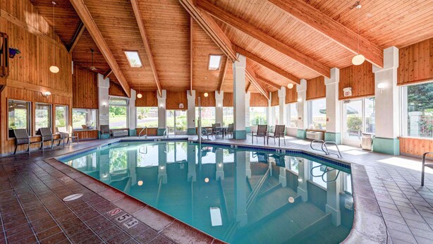 An indoor swimming pool with wooden beams and large windows. - SureStay Plus Hotel by Best Western Redding (Redding)