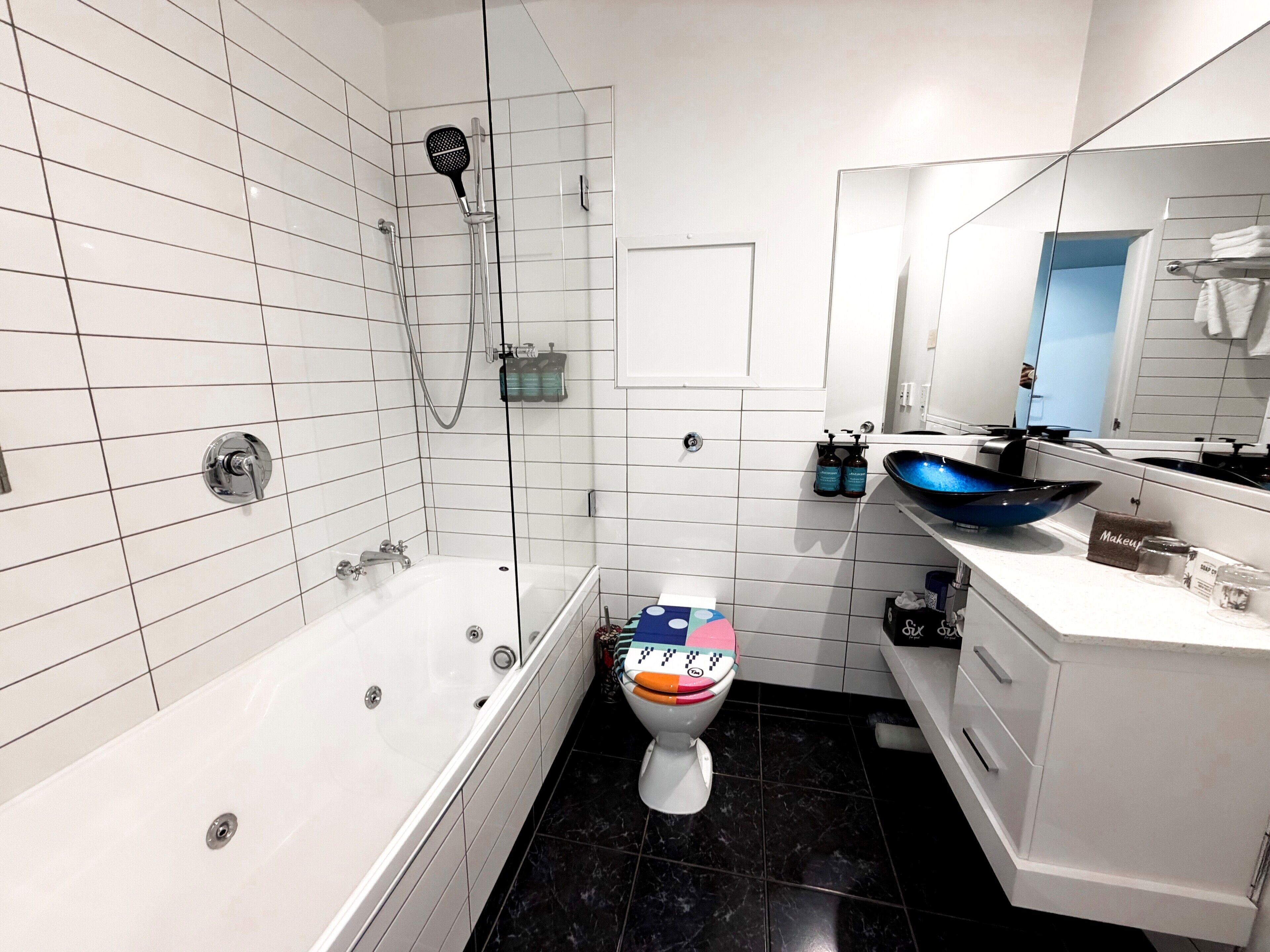 Un baño moderno con bañera, ducha e inodoro.
