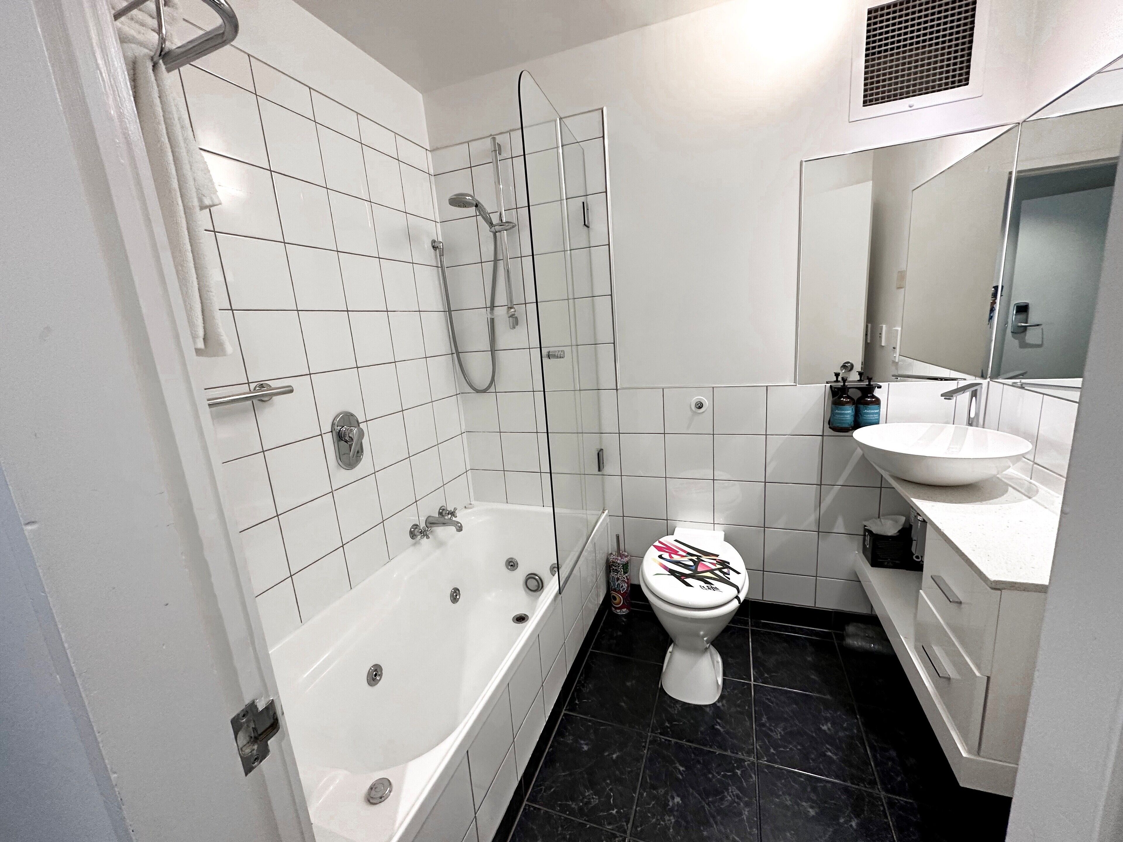 Un baño moderno con bañera, ducha, inodoro y lavamanos.