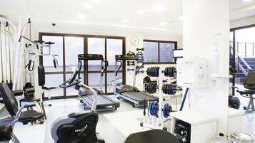 Academia com equipamentos de cardio, máquinas de peso e esteira.
