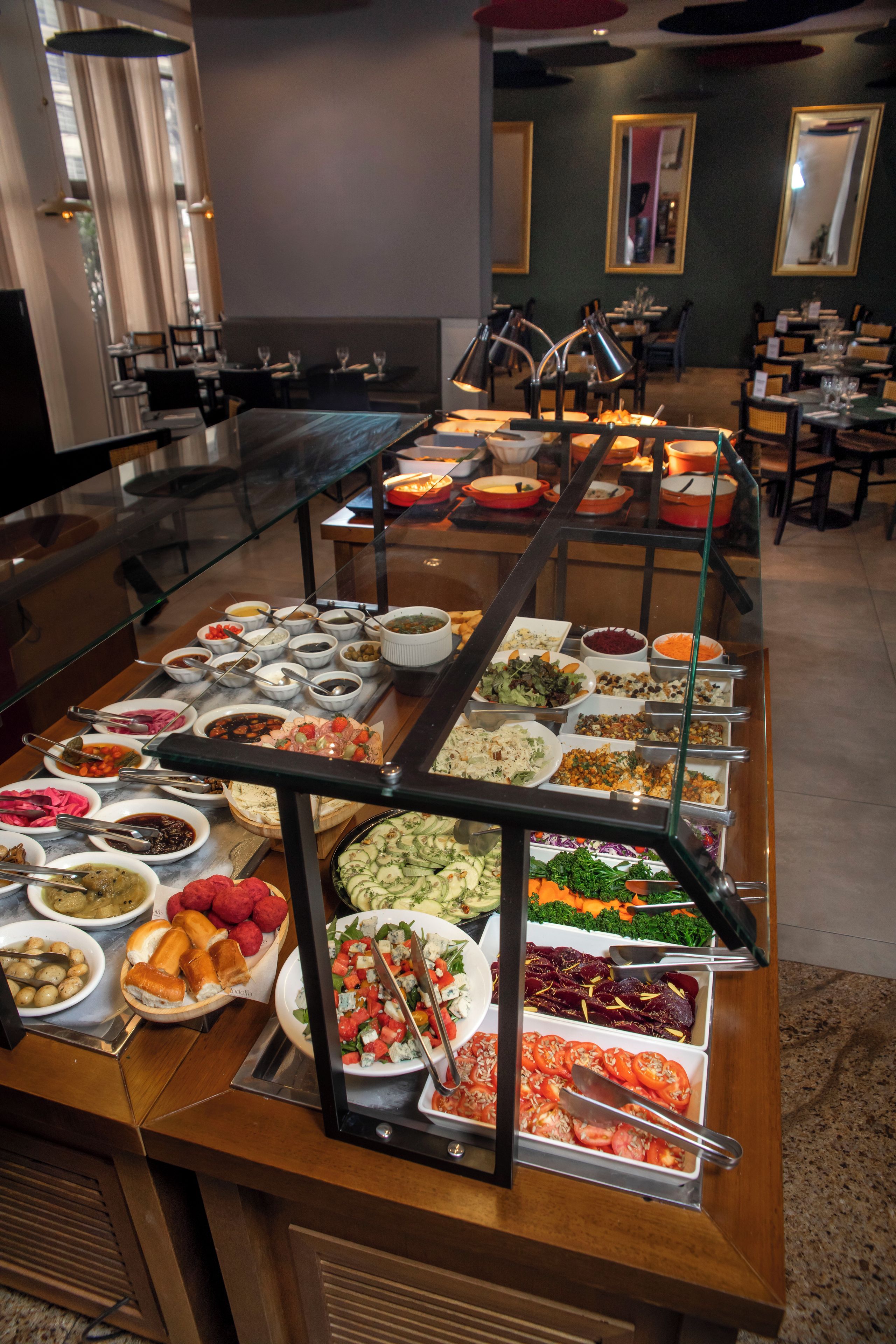 Un buffet proposant une variété de plats, notamment des salades, des viandes et des desserts.