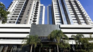 Un hôtel moderne composé de plusieurs immeubles de grande hauteur, doté de grandes fenêtres en verre et d’une entrée imposante avec une enseigne.
