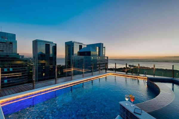 Una piscina al aire libre, sillones reclinables de piscina