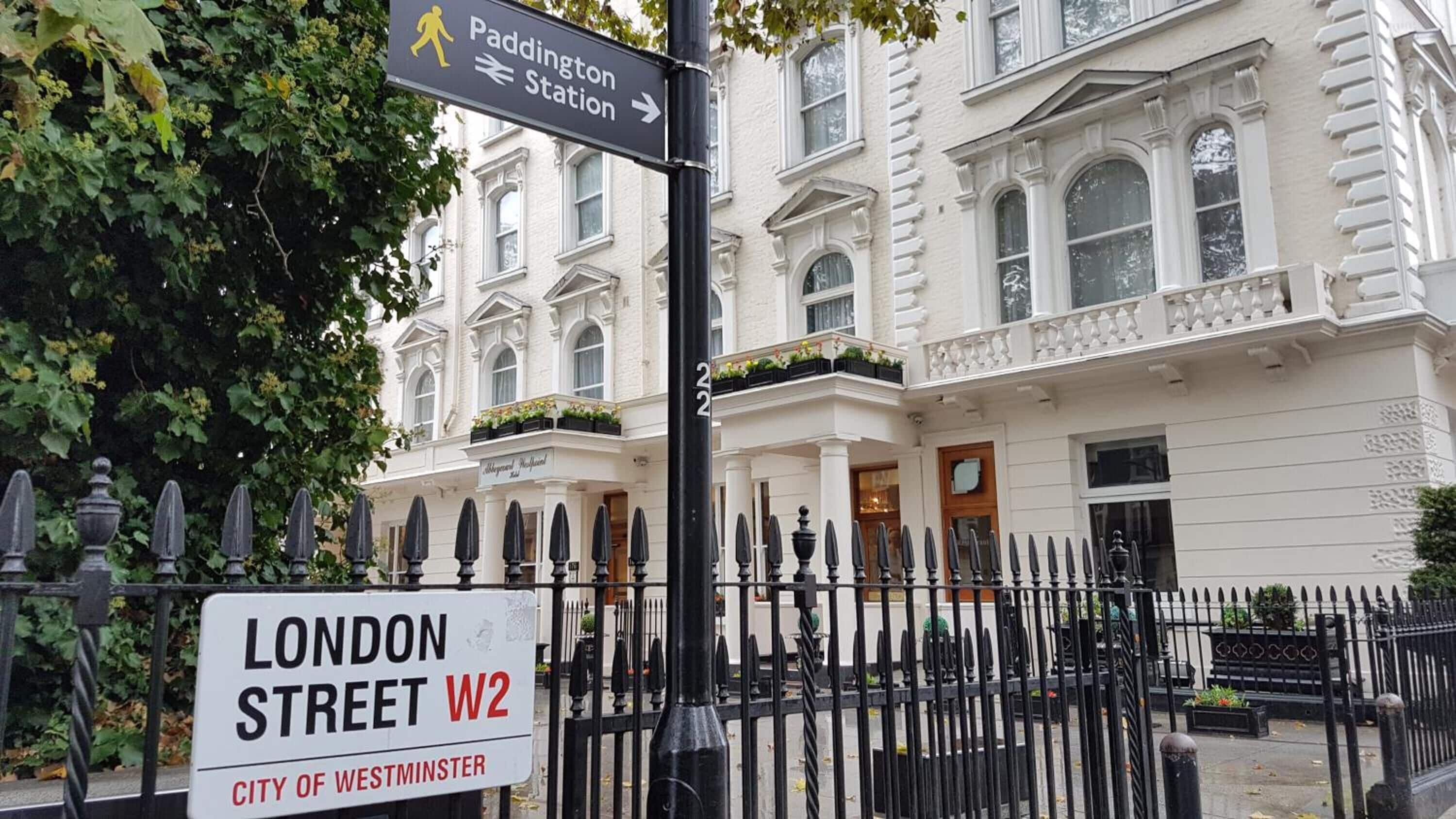 A London Street W2 sign with a Paddington Station direction sign.