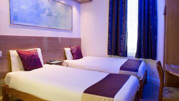 A hotel room with two beds, a wooden headboard, a nightstand, a desk, and a chair.