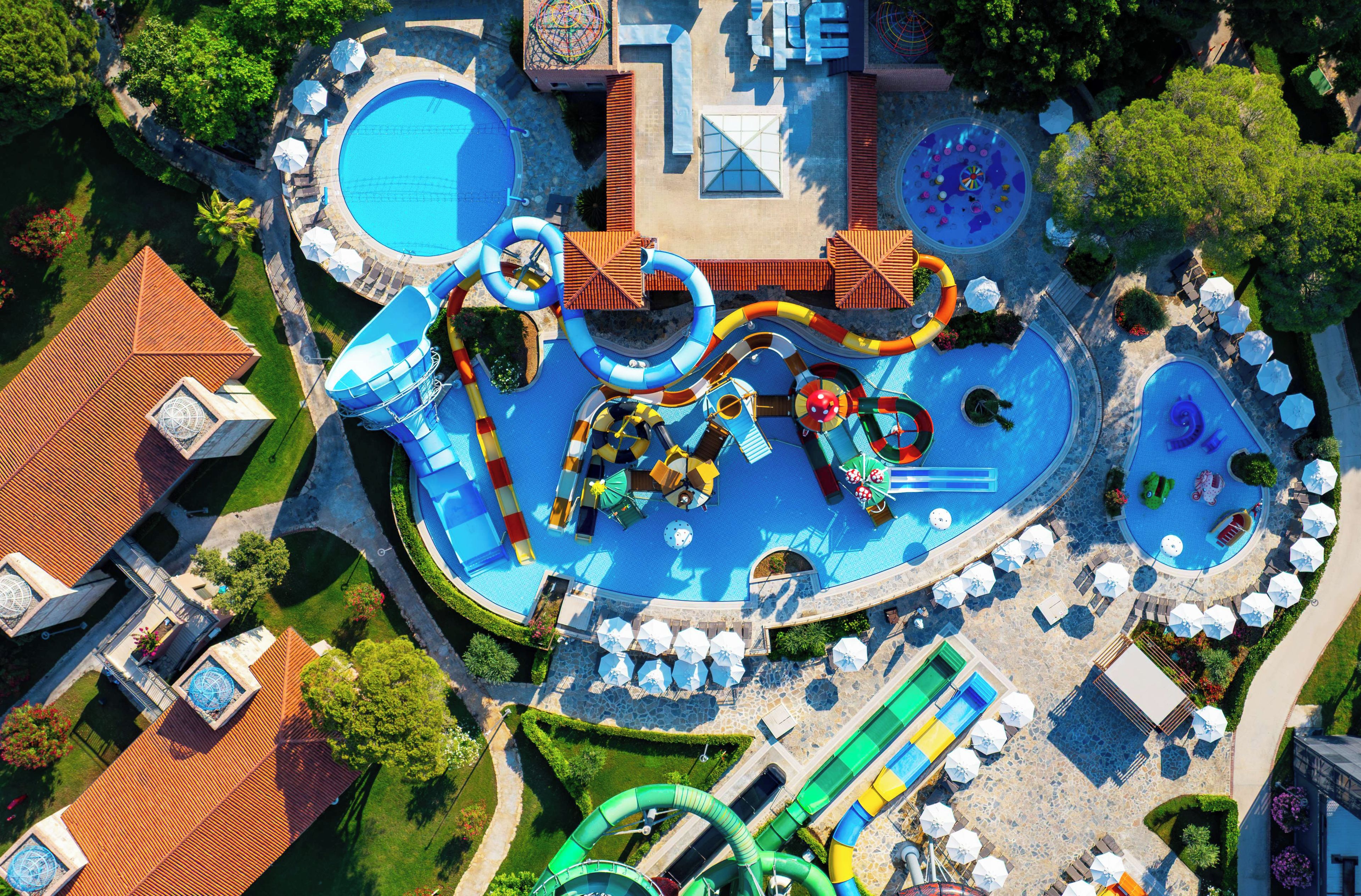 Vue aérienne d’un parc aquatique avec de nombreux toboggans et plusieurs piscines.
