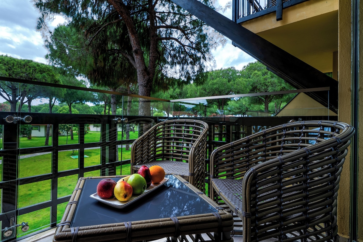 A balcony with wicker furniture and a tray of fruit.