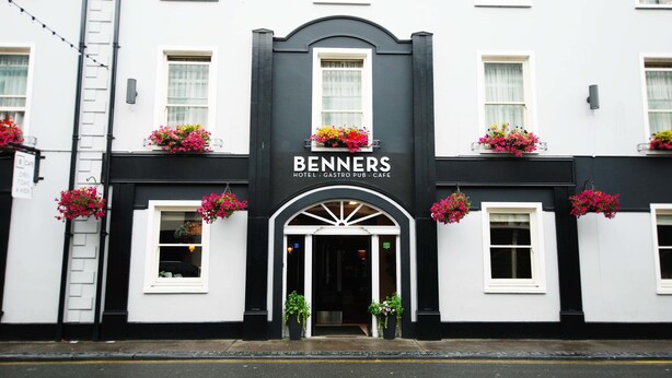 A black and white building with the name "BENNERS HOTEL" and "GASTRO PUB" above the entrance. There are flower boxes on the windowsills. - Benners Hotel (Tralee)
