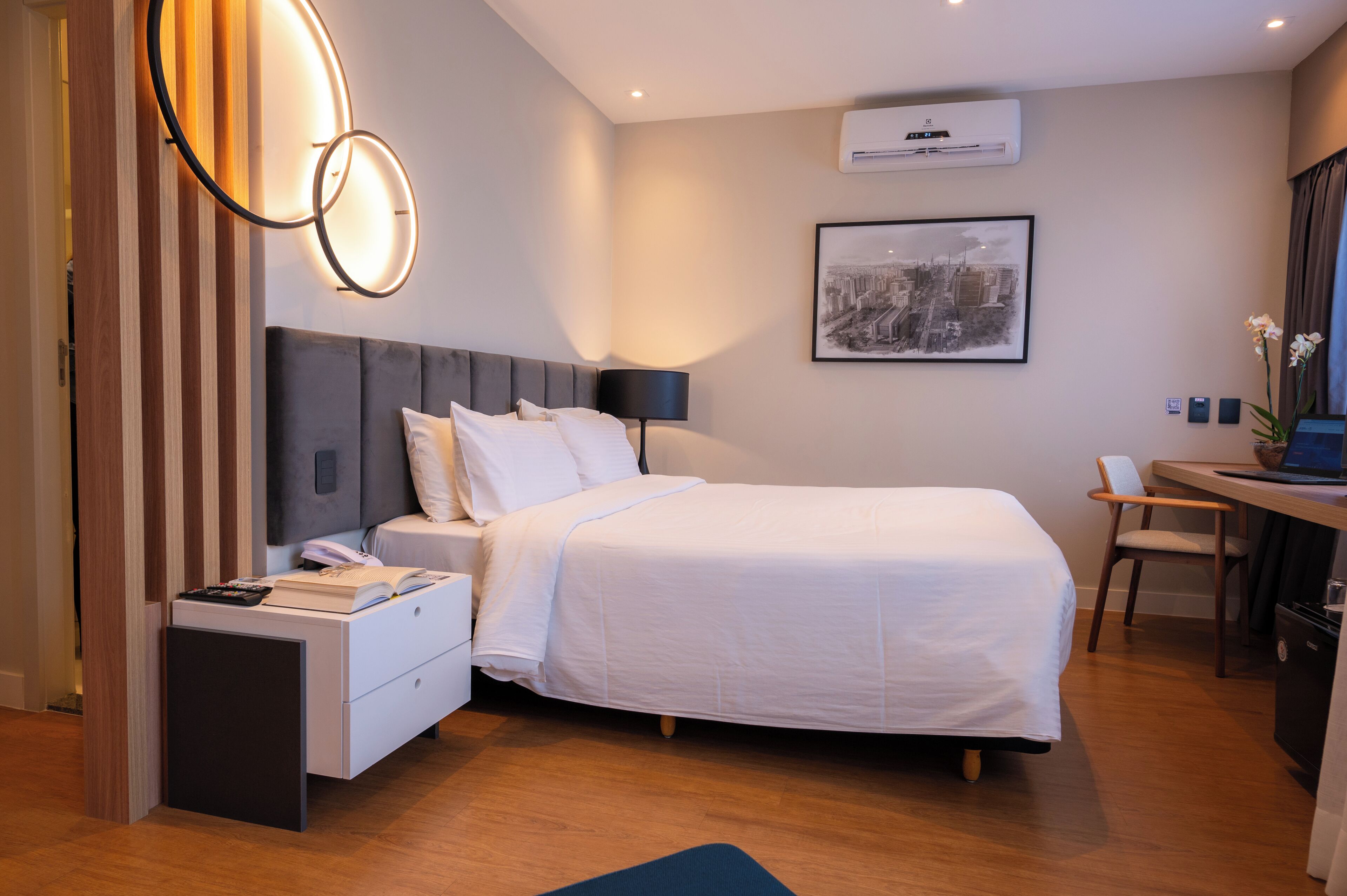 Een moderne hotelkamer met een groot bed, nachtkastjes, een bureau en een stoel.