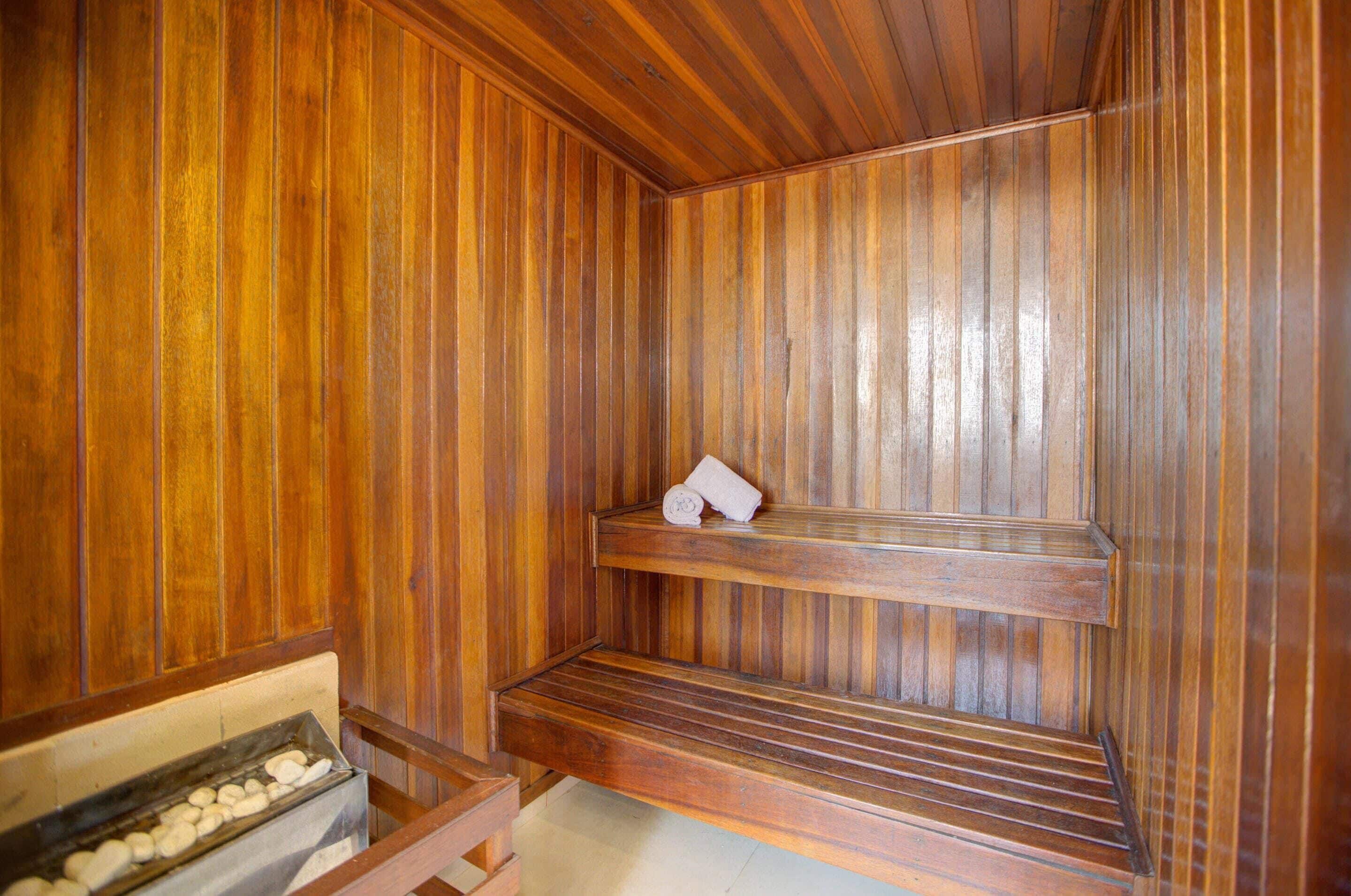 Un sauna avec des murs en bois et un banc.