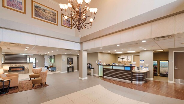 A spacious lobby with a reception desk, seating area, and a chandelier. - Best Western Plus Delta Inn & Suites (Oakley)