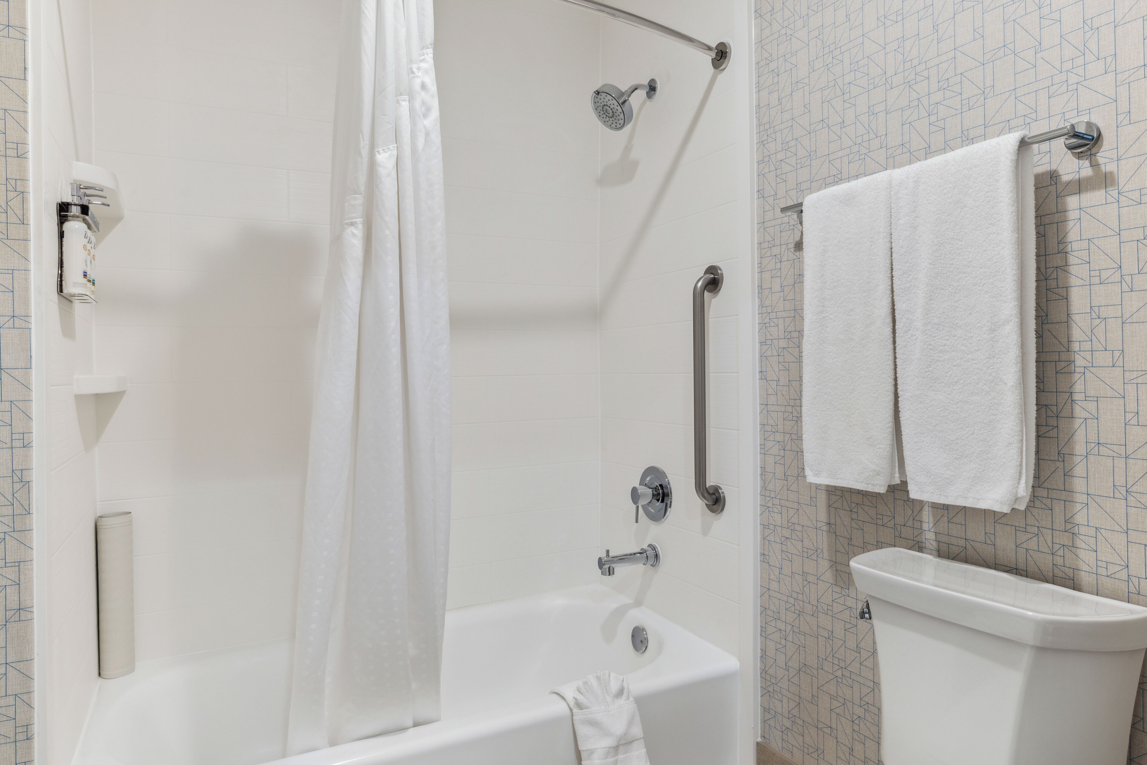 Une salle de bain avec une douche, des toilettes et un porte-serviettes.