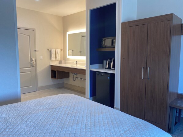 Relax in a spacious room with a large bed, wardrobe, and compact kitchenette.