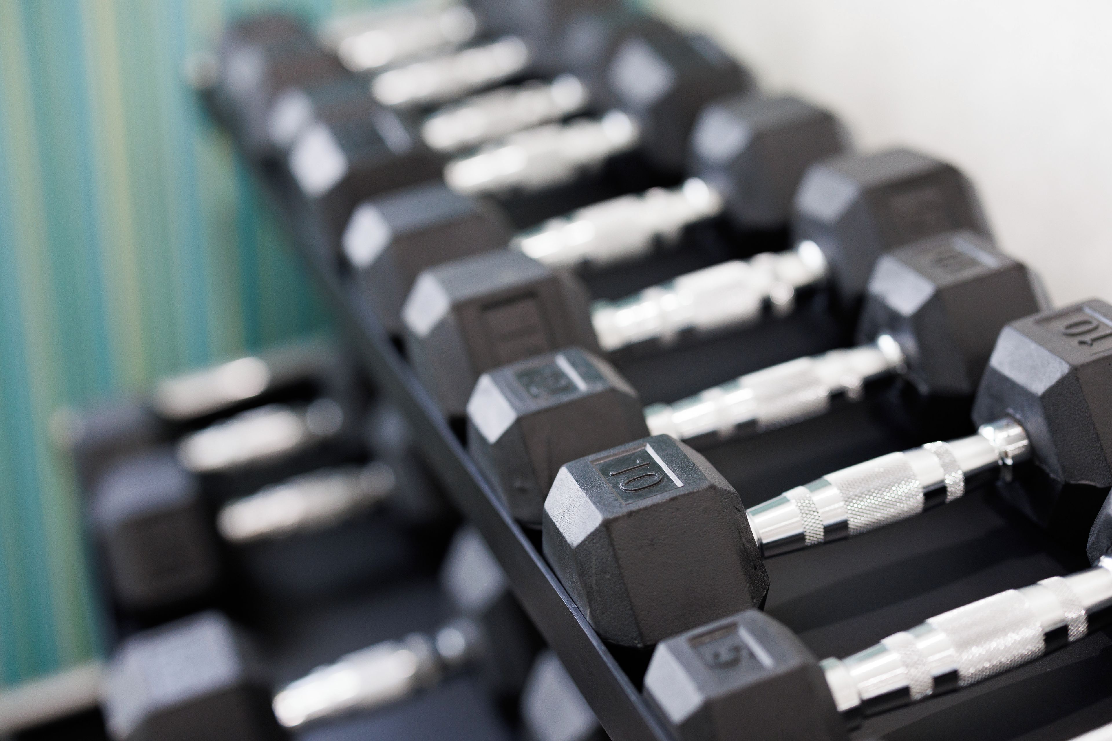 A rack of black dumbbells with weight markings.